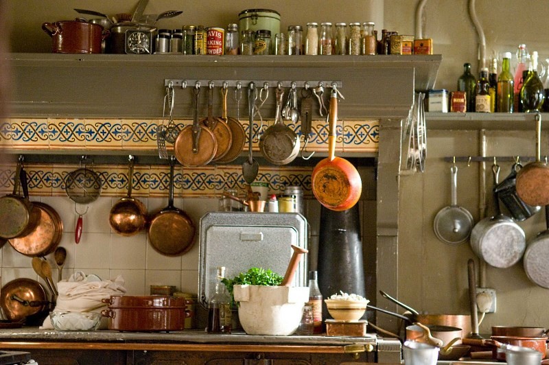 кастрюли и сковородки висящие на кухне