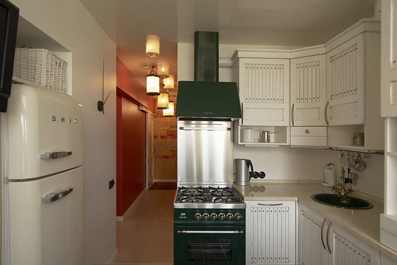 Холодильник в стене между маленькой кухней и комнатой