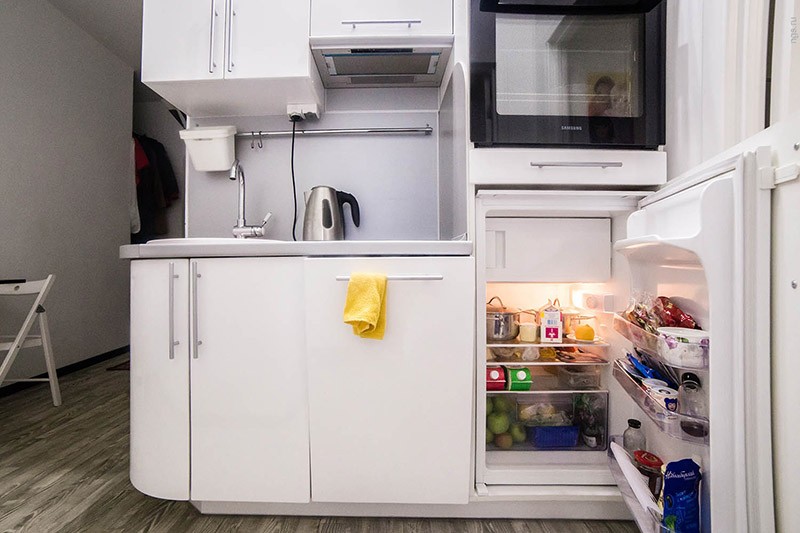 Маленький холодильник спрятан за фасад шкафа