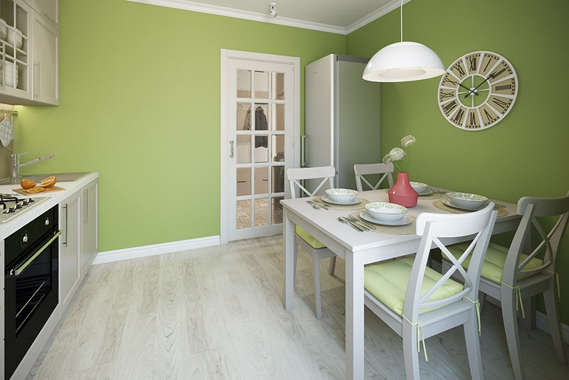 Белый стол и стулья простой формы на зеленой кухне